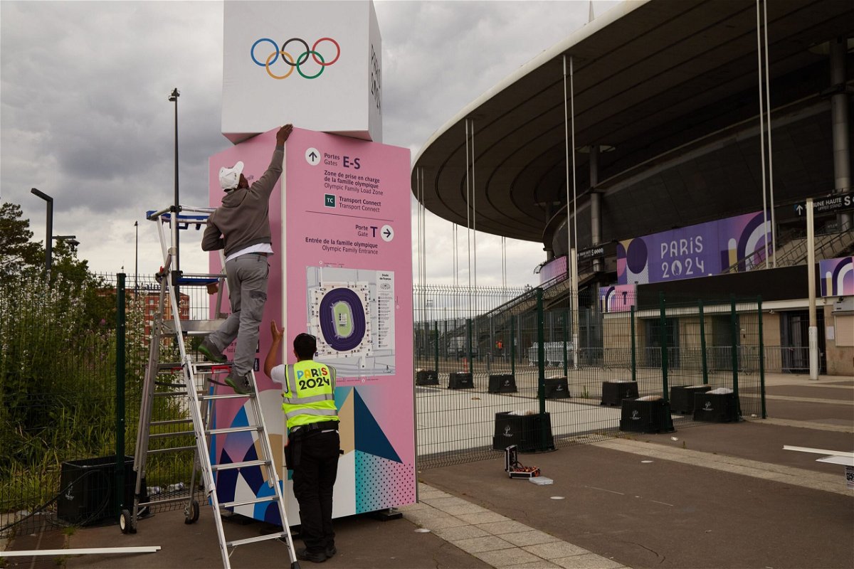 <i>Pierre Crom/Getty Images via CNN Newsource</i><br/>Workers prepare an information board outside Stade de France in Saint Denis on July 3. The Paris 2024 Olympic Games will run from July 26 to August 11.