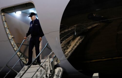 President Joe Biden gestures to reporters as he steps off Air Force One upon arrival at Dover Air Force Base in Dover