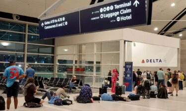 Travelers wait in a long line to speak with a Delta representative at the help desk in the McNamara terminal at the Detroit Metropolitan Wayne County Airport on July 20 in Detroit