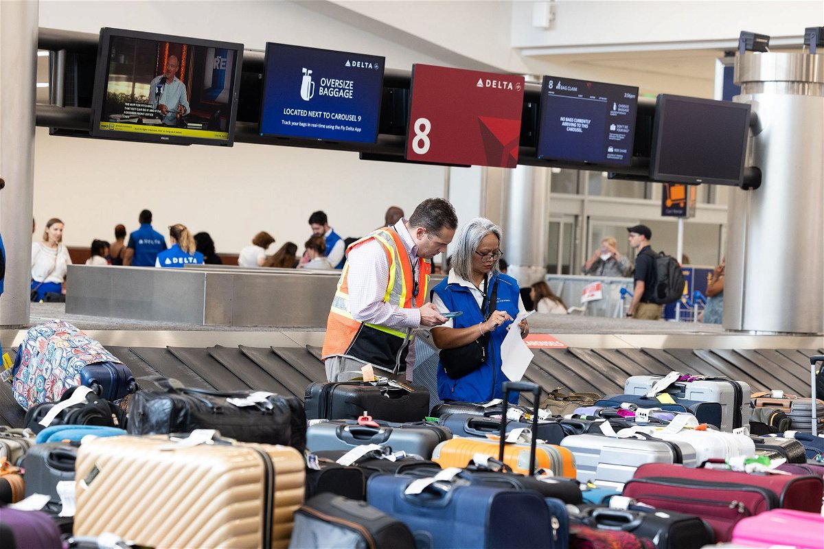 <i>Jessica McGowan/Getty Images via CNN Newsource</i><br/>Delta Air Lines employees try to locate passengers' luggage after cancelled and delayed flights at Hartsfield-Jackson Atlanta International Airport on July 22.
