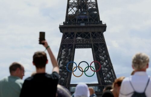 Visitors look at The Eiffel Tower adorned with The Olympic Rings ahead of the 2024 Olympic Games in Paris on July 16.