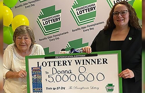 Winner Donna Osborne holds her check with Pennsylvania Lottery Deputy Director of Corporate Sales Staci Coombs.