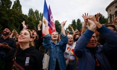 Supporters of the far-left France Unbowed party celebrate the second round results in Paris