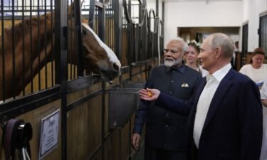 Russian President Vladimir Putin and Indian Prime Minister Narendra Modi visit a stable during an informal meeting outside Moscow