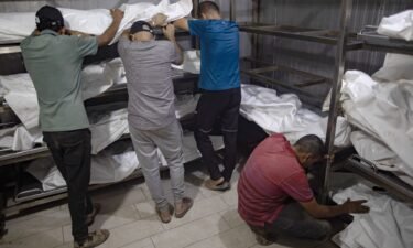 Relatives of killed Palestinians cry next to their bodies inside the morgue at Nasser Hospital in Khan Younis on July 9