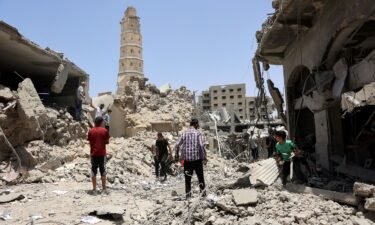 Rescuers stand on the rubble of destroyed buildings following Israeli bombardment near to the Great Omari Mosque in the Old City of Gaza City.