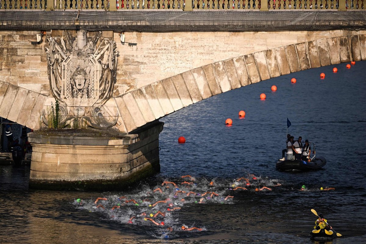 <i>Emmanuel Dunand/AFP/Getty Images via CNN Newsource</i><br/>Triathlon athletes swim in the Seine river during the men's 2023 World Triathlon Olympic Games Test Event in Paris