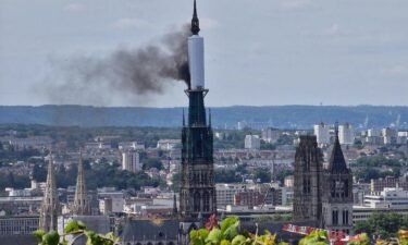 Smoke billows from the spire of Rouen Cathedral in Rouen