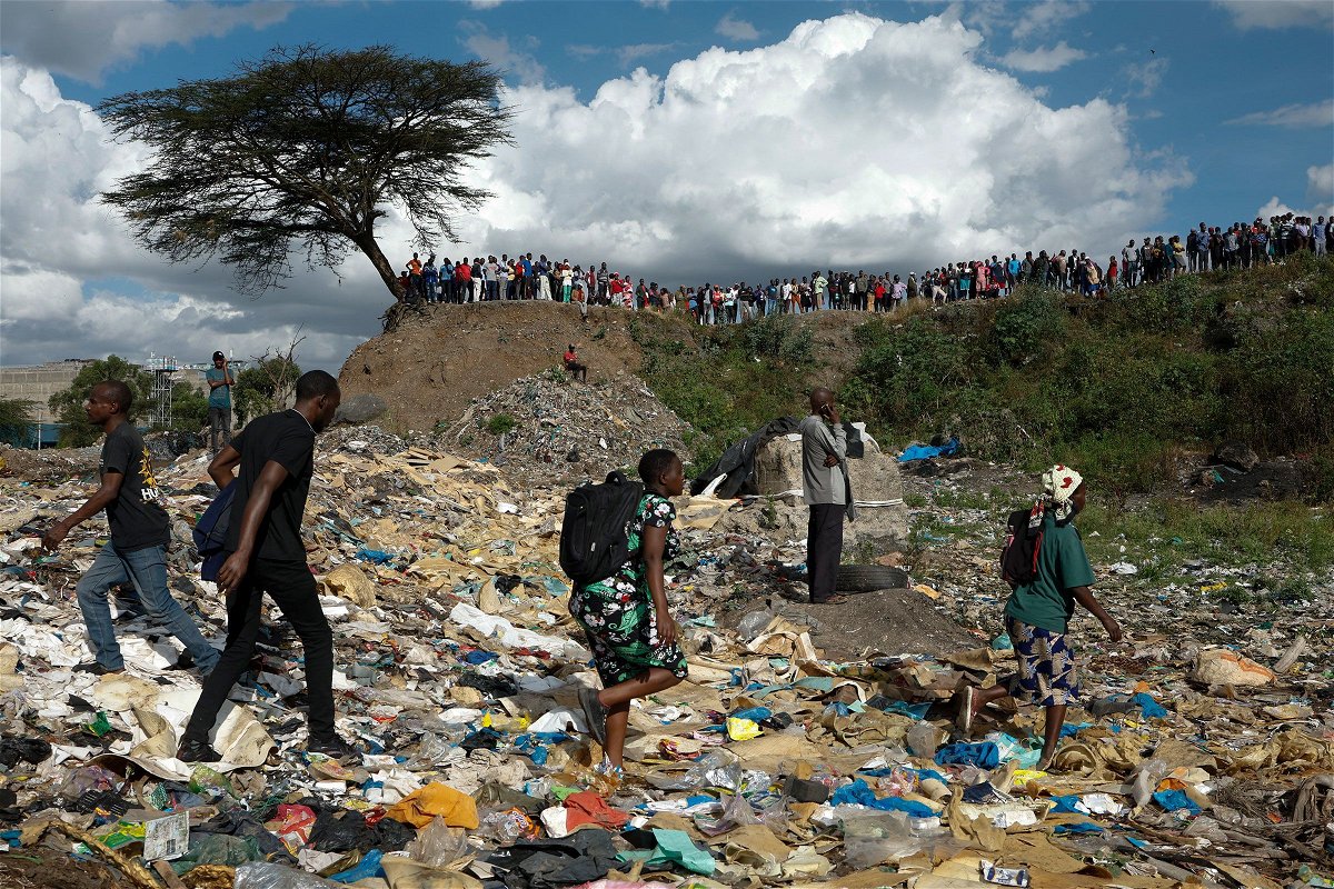 <i>Simon Maina/AFP/Getty Images via CNN Newsource</i><br/>People walk among rubbish as others stand on the edge of a dumpsite where six bodies were found at the landfill in Mukuru slum