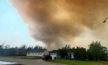 Smoke from an encroaching wildfire is seen over homes after an evacuation was ordered in the eastern Canadian community of Labrador City