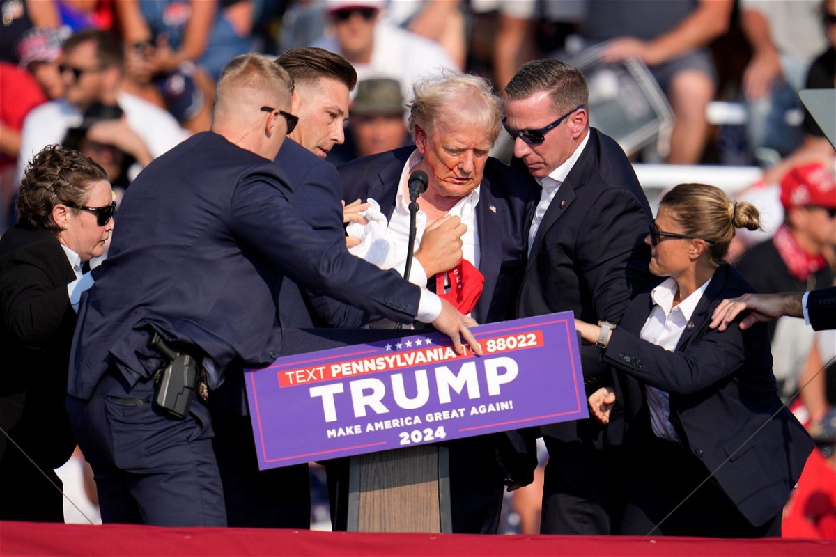 <i>Gene J. Puskar/AP via CNN Newsource</i><br/>Former President Donald Trump is helped off the stage at a campaign event in Butler