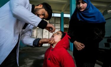A government health worker administers polio drops to a child in Srinagar