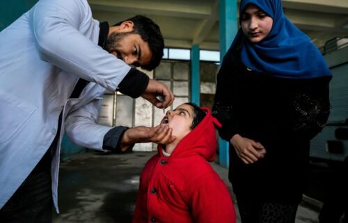 A government health worker administers polio drops to a child in Srinagar