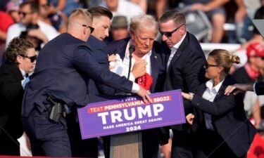 Former President Donald Trump is helped off the stage at a campaign event in Butler