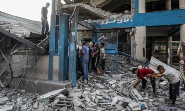 Palestinians and UN workers examine the destroyed UNRWA school in Nuseirat refugee camp of Deir al-Balah