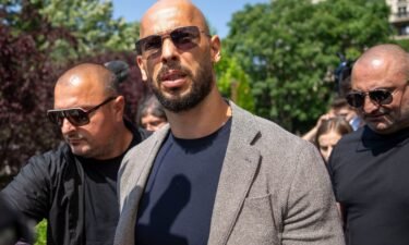 Andrew Tate walks between bodyguards in Bucharest