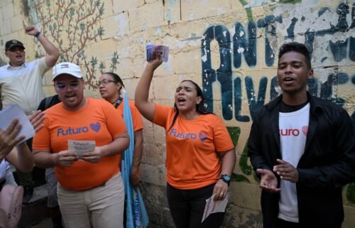 Supporters of Venezuelan President Nicolas Maduro hand out flyers in the neighborhood of Agua de Maiz in Caracas on July 11
