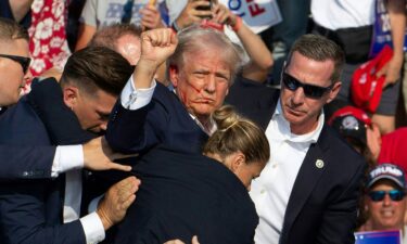 Donald Trump is surrounded by secret service agents as he is taken off the stage at a campaign event at Butler Farm Show Inc. in Butler