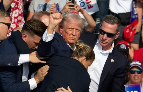Donald Trump is surrounded by secret service agents as he is taken off the stage at a campaign event at Butler Farm Show Inc. in Butler