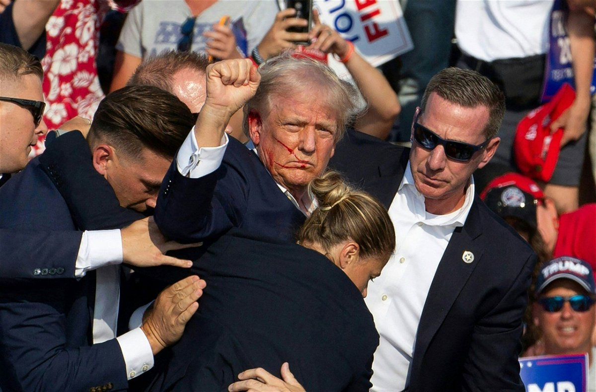 <i>Rebecca Droke/AFP via Getty Images via CNN Newsource</i><br/>Donald Trump is surrounded by secret service agents as he is taken off the stage at a campaign event at Butler Farm Show Inc. in Butler