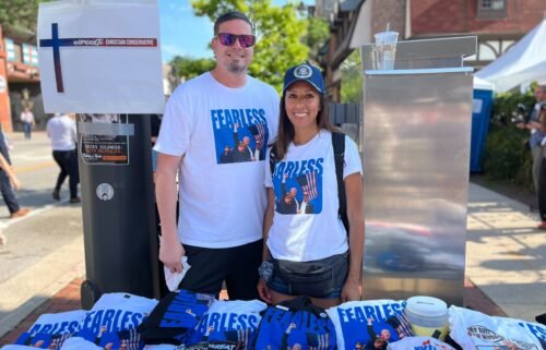 Brad and Andrea Neuser pose with their merchandise being sold outside of the Republican National Convention in Milwaukee