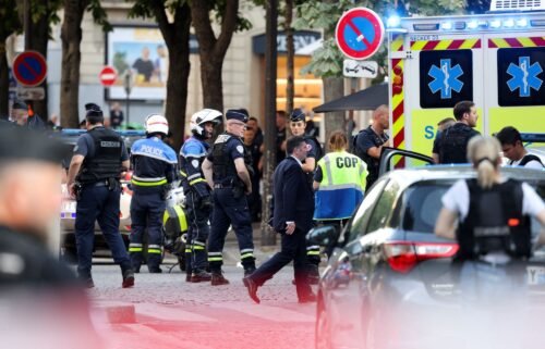 Police stand next to an ambulance after an officer was injured in an attack next to the Champs-Elysees avenue
