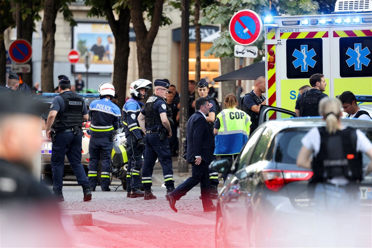 <i>Kevin Coombs/Reuters via CNN Newsource</i><br/>Police stand next to an ambulance after an officer was injured in an attack next to the Champs-Elysees avenue