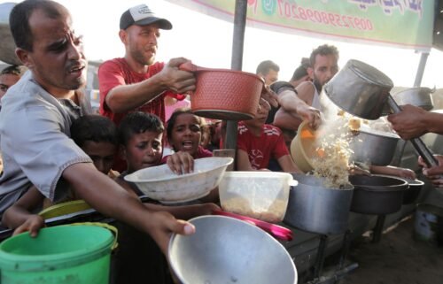 Palestinians collect food aid ahead of the upcoming Eid al-Adha holiday in Khan Younis