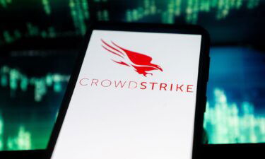In this photo illustration a Crowdstrike logo seen displayed on a smartphone. The global computer outage affecting airports