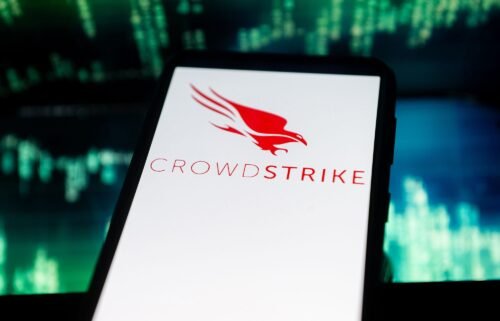 In this photo illustration a Crowdstrike logo seen displayed on a smartphone. The global computer outage affecting airports