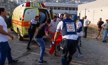 Israeli security forces and medics transport casualties along with local residents