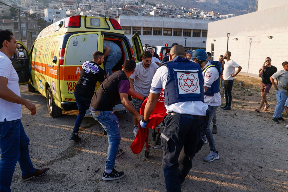 <i>Jalaa Marey/AFP/Getty Images via CNN Newsource</i><br/>Israeli security forces and medics transport casualties along with local residents