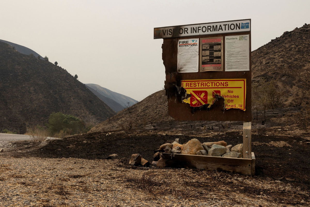 <i>Matt Mills McKnight/Reuters via CNN Newsource</i><br/>A burned visitor information sign from the Durkee Fire is pictured amid charred hillside near Huntington