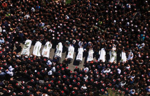 Druze elders and mourners surround the coffins of 10 of the children killed during the strike on July 27.
