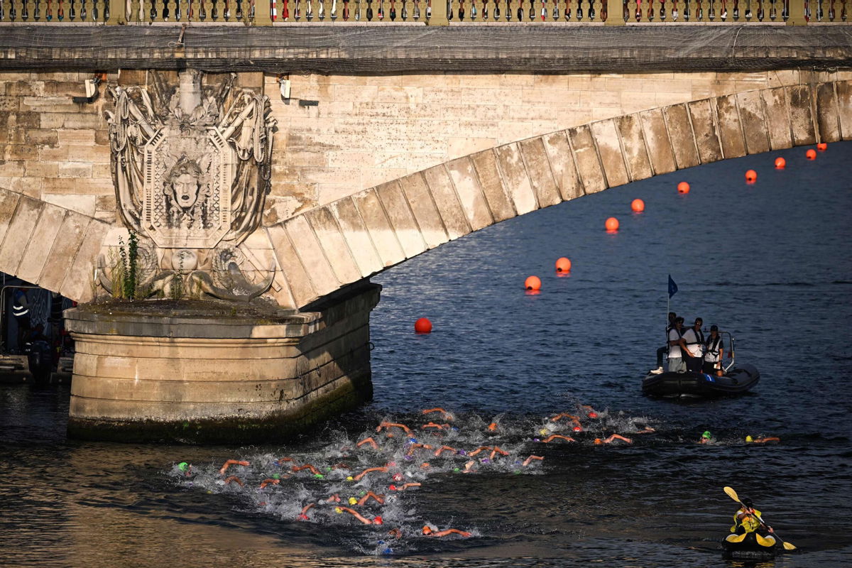 <i>Emmanuel Dunand/AFP/Getty Images via CNN Newsource</i><br/>Triathlon athletes swim in the River Seine during the men's 2023 World Triathlon Olympic Games Test Event in Paris on August 18