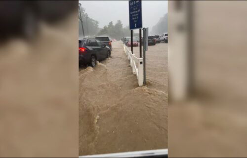 Part of Dollywood's parking lot can be seen flooded as cars try to exit the grounds