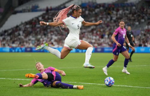 Trinity Rodman (center) of the United States jumps over the tackle of Alexandra Popp (left) of Germany during the Paris Olympics 2024.