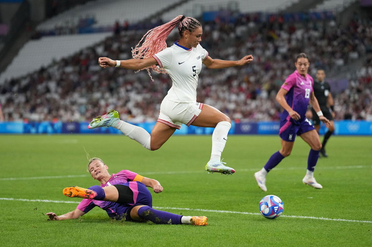 <i>Brad Smith/ISI/Getty Images via CNN Newsource</i><br/>Trinity Rodman (center) of the United States jumps over the tackle of Alexandra Popp (left) of Germany during the Paris Olympics 2024.