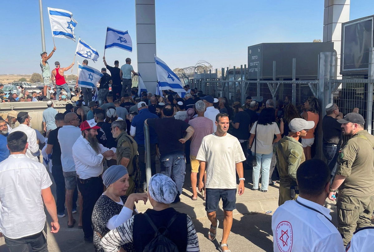 <i>Jill Gralow/Reuters via CNN Newsource</i><br/>Right-wing protesters wave Israeli flags outside Sde Teiman detention facility on July 29.
