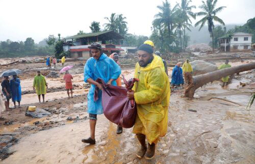 Rescuers carry the body of a victim at a landslide site in Wayanad