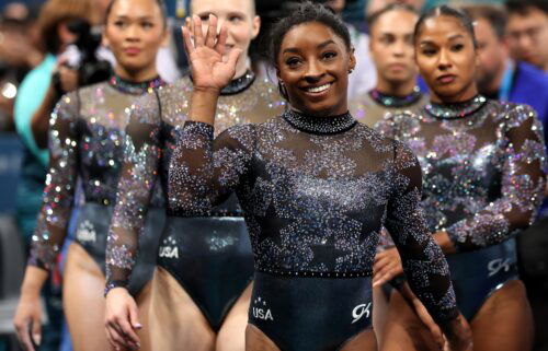 Simone Biles waves as she is joined by members of Team USA after artistic gymnastics women's qualification.