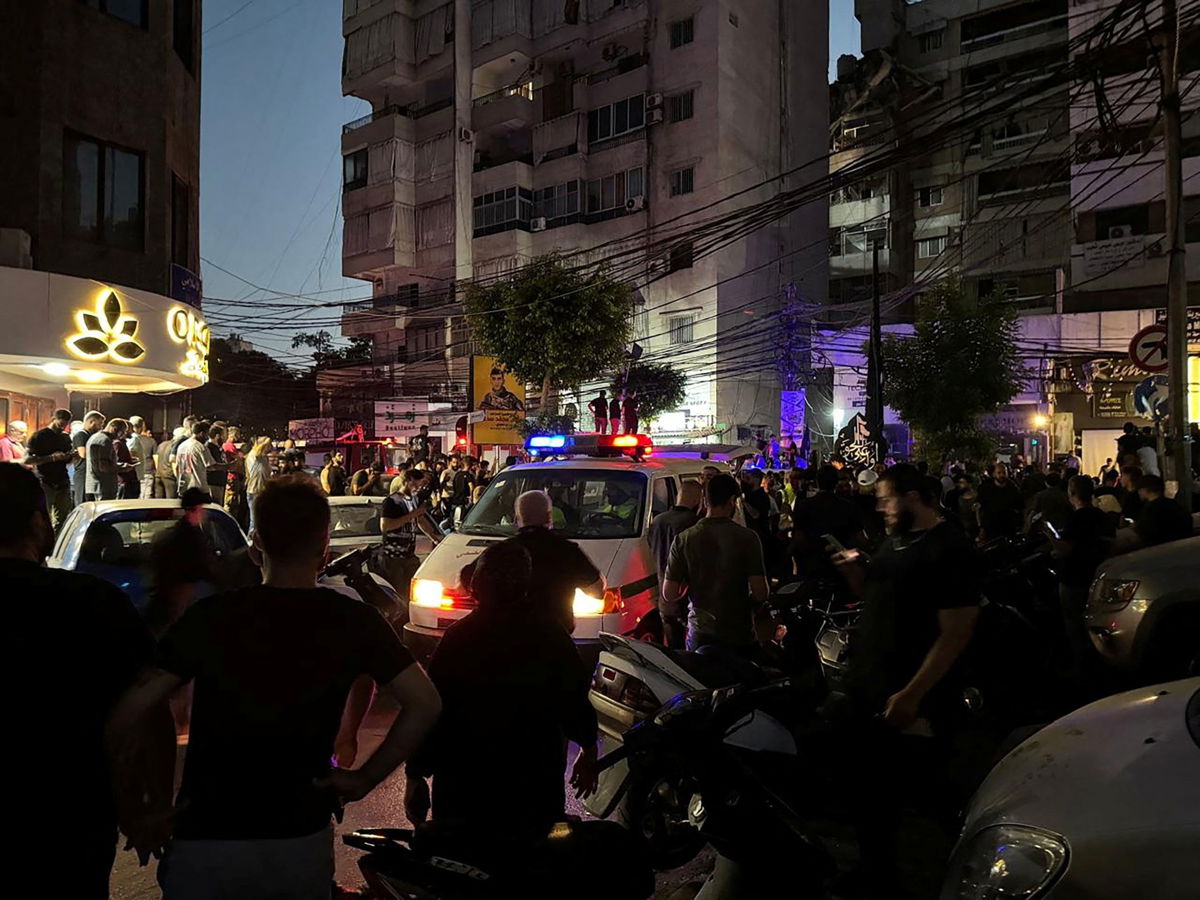 <i>Ahmad Al-Kerdi/Reuters via CNN Newsource</i><br/>People gather near a site hit by what security sources said was a strike on the southern suburbs of Beirut