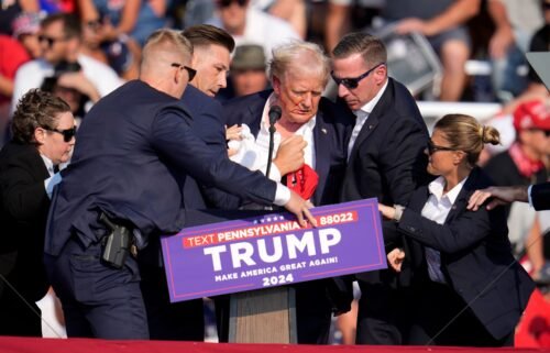 Republican presidential candidate former President Donald Trump is helped off the stage at a campaign event in Butler