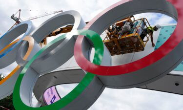 A worker puts on the finishing touches on a sign outside a venue ahead of the 2024 Summer Olympics on July 22