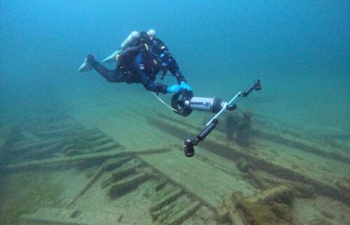 A diver from the Wisconsin Historical Society collects photos for a 3D photogrammetry model of the Muir.