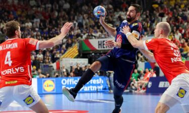 Handball player prepares to shoot the ball at goal.