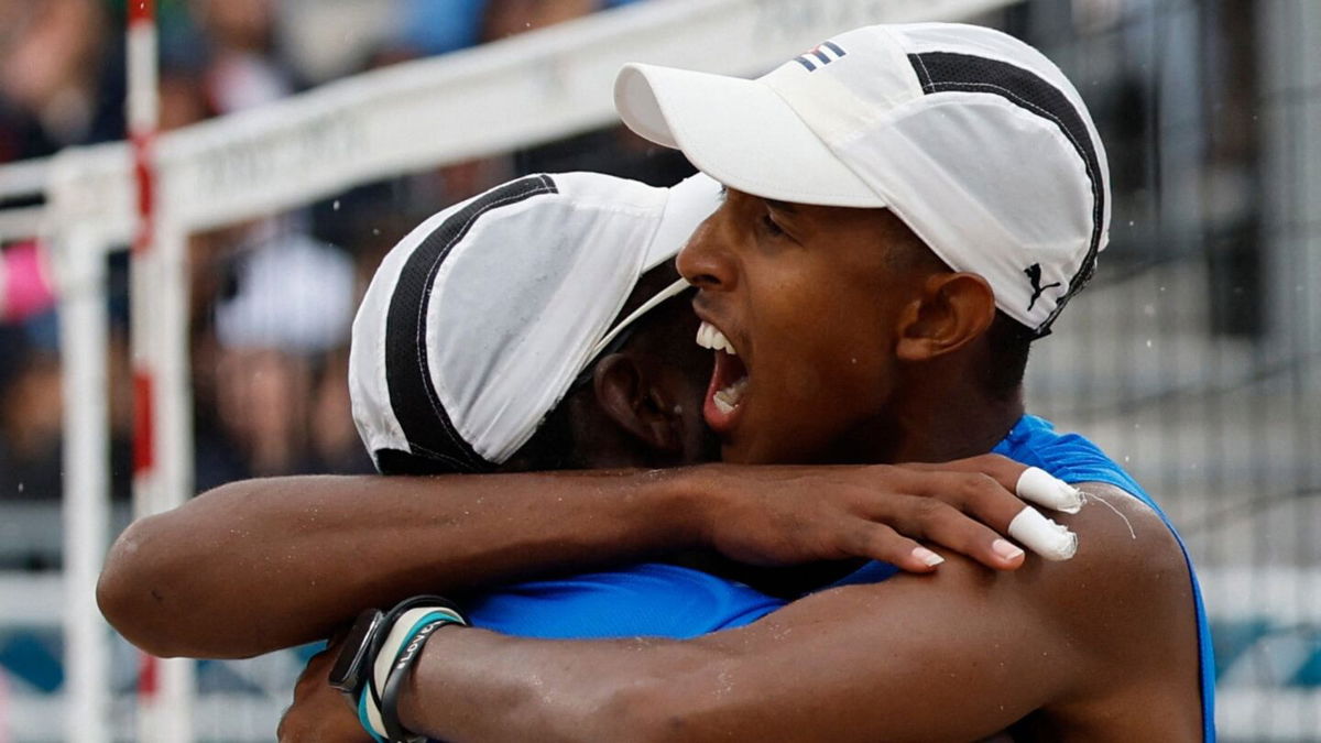 Cuba's Noslen Diaz and Jorge Alayo embrace during their Pool D match against the United States