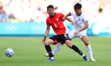 Players from both teams chase after the ball.