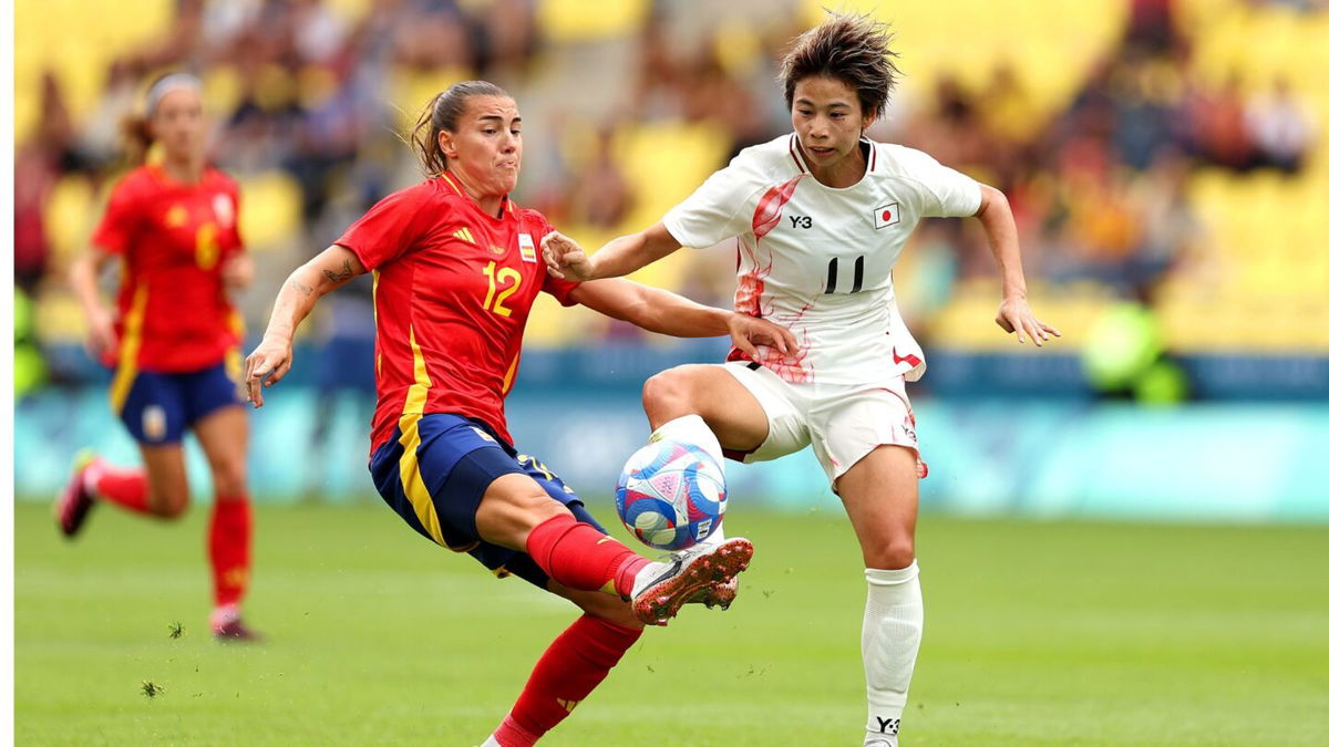 Two soccer athletes contest for the ball.