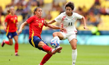 Two soccer athletes contest for the ball.